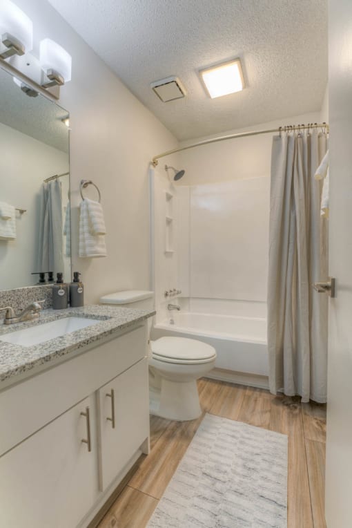 a bathroom with a shower and a toilet and a sink at Brightwaters Apartments, Little Rock, AR