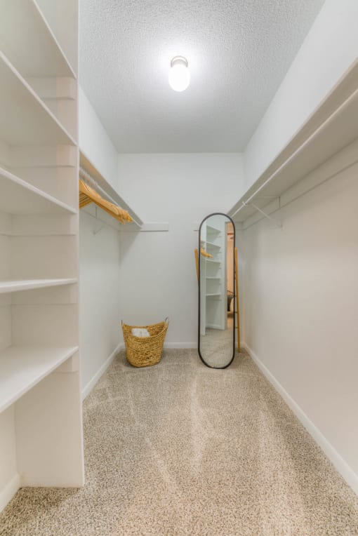 a walk in closet with shelves and a mirror at Brightwaters Apartments, Little Rock