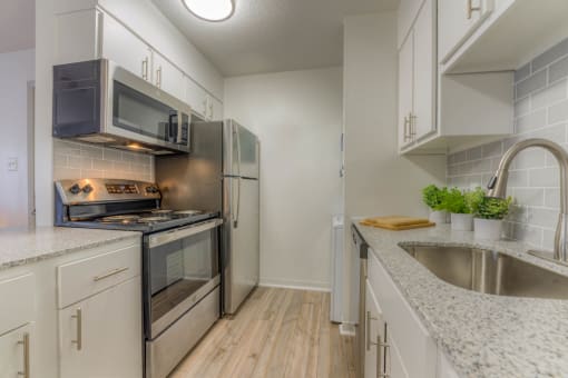 a kitchen with white cabinets and stainless steel appliances at Brightwaters Apartments, Little Rock, AR