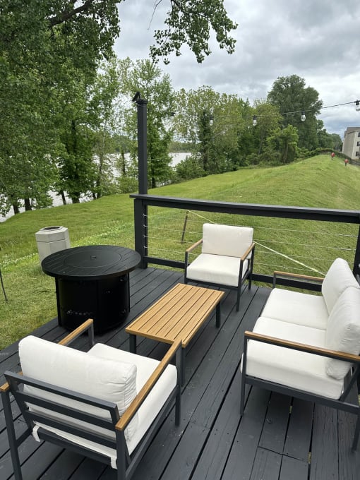 a patio with a table and chairs and a fire pit at Brightwaters Apartments, Arkansas