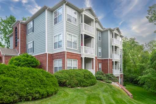 A large apartment building with a green lawn in front.