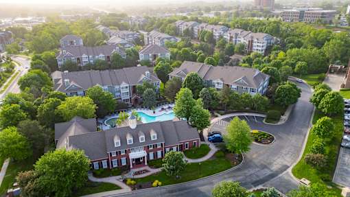 A bird's eye view of a residential area with houses and a swimming pool.