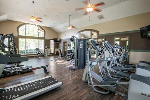 A gym with treadmills, elliptical machines, and other exercise equipment.
