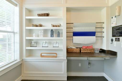 A kitchen pantry with white shelves and a blue and white striped towel hanging on the wall.