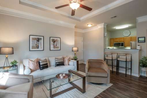A living room with a couch, chair, and a glass table.