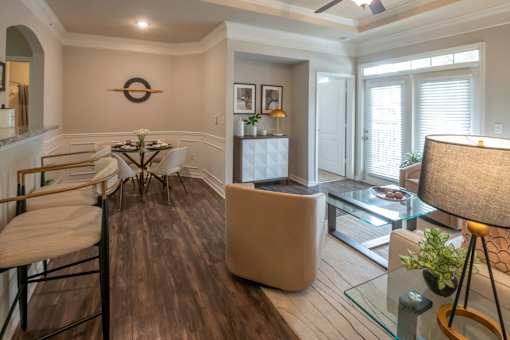 A modern living room with a glass coffee table and a white sofa.