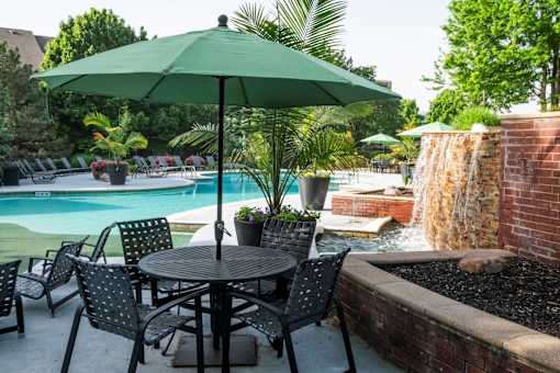 A patio with a table, chairs and an umbrella.