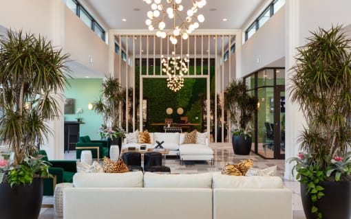 a living room filled with furniture and plants at Esplanade District Apartments, Little Rock, AR