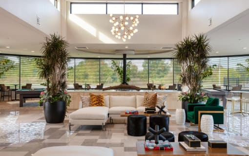 the lobby of a hotel with a couch and chairs and large windows at Esplanade District Apartments, Little Rock, AR,72114