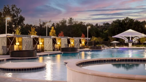 a swimming pool at night with a sunset in the background at Esplanade District Apartments, Little Rock, AR,72114