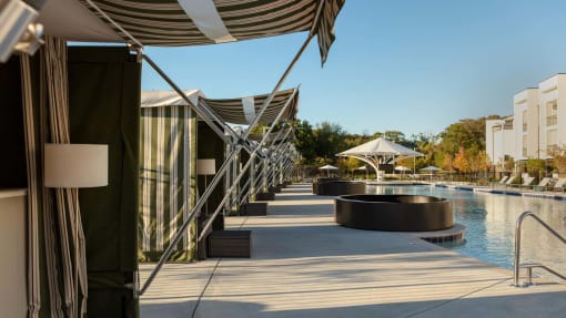 a resort with a pool and umbrellas at Esplanade District Apartments, Little Rock