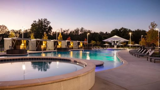 a swimming pool at night at the resort at governors island at Esplanade District Apartments, Little Rock, 72114