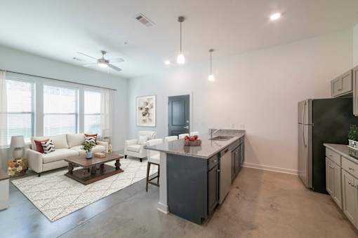 A modern kitchen with a white couch and a wooden coffee table.