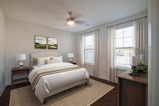 A bedroom with a large bed and a ceiling fan.