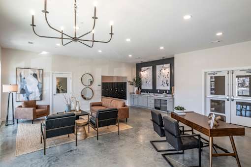 A modern living room with a large chandelier and a variety of seating options.