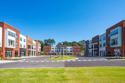 A large grassy area in front of a row of buildings.