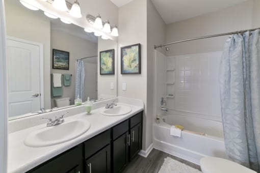 a bathroom with two sinks and a shower and a tub at Legends at Chatham, Savannah, GA