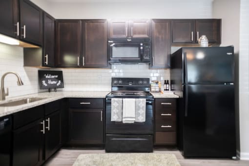 a black and white kitchen with black appliances and black cabinets