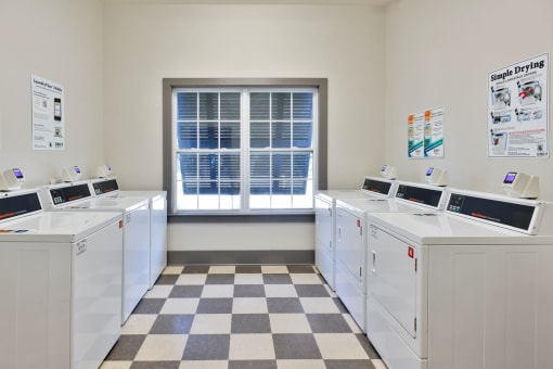 a group of washing machines in a room with a window
