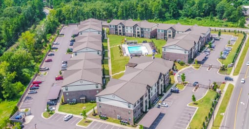 an aerial view of a building with cars parked in a parking lot