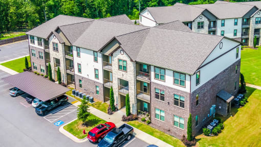 an aerial view of an apartment building with cars parked outside