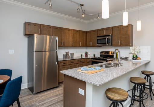 a kitchen with stainless steel appliances and granite counter tops at The McKenzie Park Apartments, Little Rock