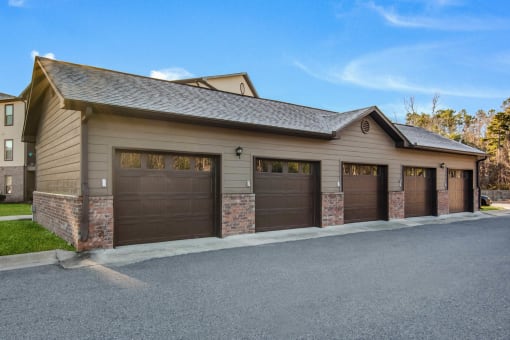 a garage with three garage doors in front of a house