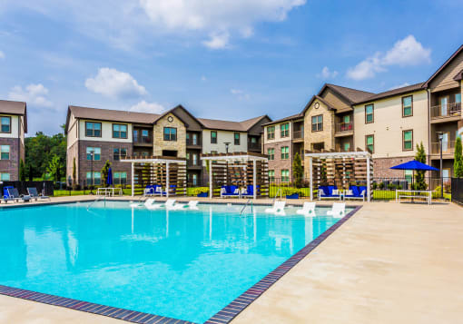 a swimming pool with an apartment building in the background