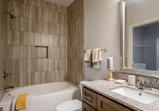 a bathroom with a tub and a sink and a mirror