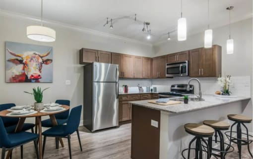 a kitchen with stainless steel appliances and a table with chairs