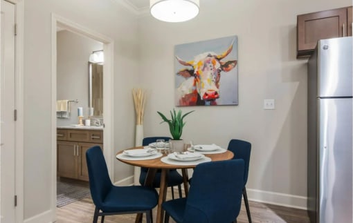 a dining room with a table and a painting of a cow