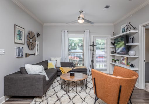 a living room with a couch and a chair and a window