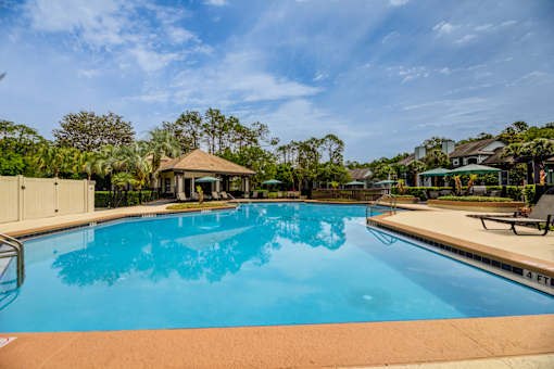 A large swimming pool with a gazebo in the background.