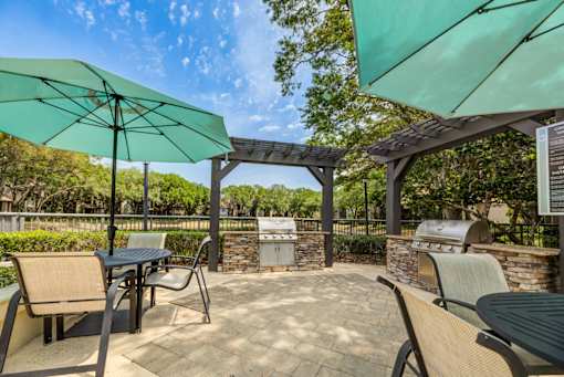 A patio with a table and chairs under a green umbrella.