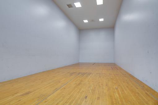A room with wooden flooring and white walls.