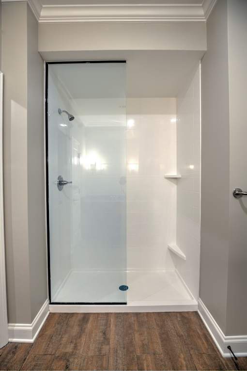 A white bathroom with a glass shower door.