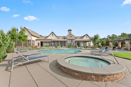 a pool with chairs and a spa in front of a house at The Ridge at Chenal Valley, Arkansas, 72223