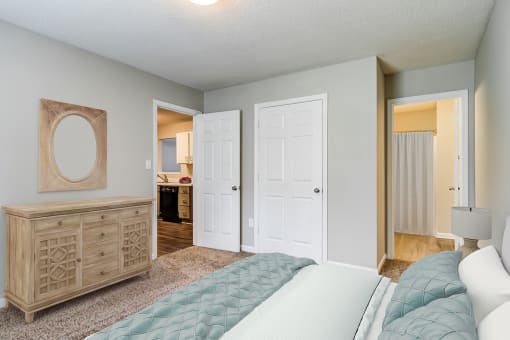 a bedroom with a bed and a dresser and a bathroom  at Serene at Creekstone, Athens, GA