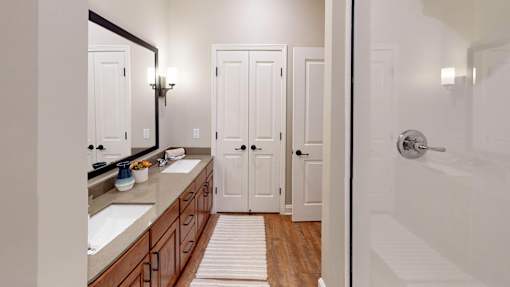 A bathroom with a sink, mirror, and white door.