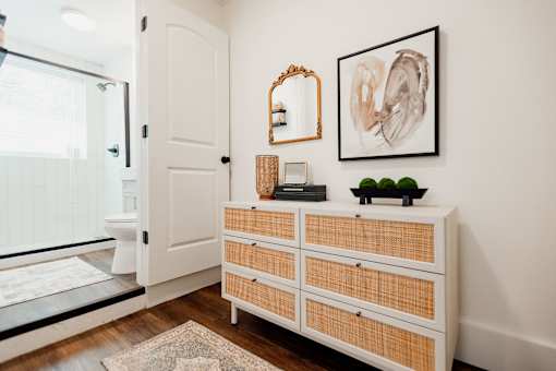A white wooden dresser with a mirror and a painting on the wall.at Parkview Apartments, Memphis, 38104