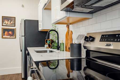 A modern kitchen with a black refrigerator and stainless steel appliances.at Parkview Apartments, Memphis Tennessee