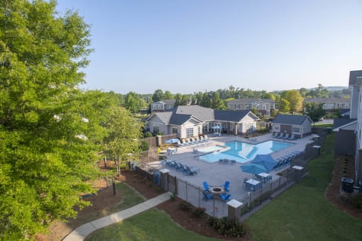 an aerial view of a swimming pool in a backyard with trees