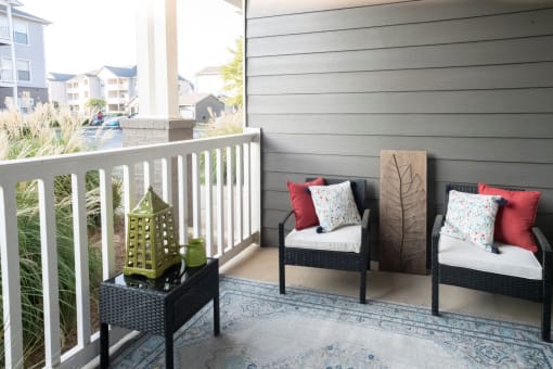 a porch with two chairs and a lantern on a balcony at The Shallowford, Chattanooga, 37421