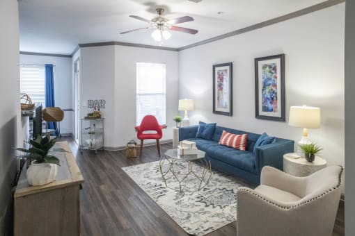 a living room with a blue couch and a ceiling fan