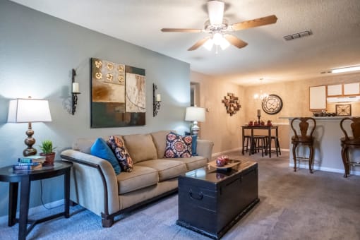 a living room with a couch and a ceiling fan at The Summit Apartments, Memphis