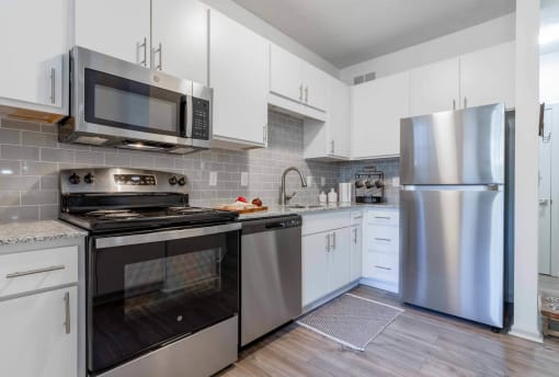 a kitchen with stainless steel appliances and white cabinets at The Waters at Chenal, Little Rock, Arkansas