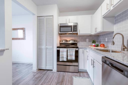 a kitchen with stainless steel appliances and white cabinets at The Waters at Chenal, Little Rock