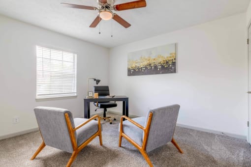 a living room with two chairs and a desk with a ceiling fan at The Waters at Chenal, Little Rock