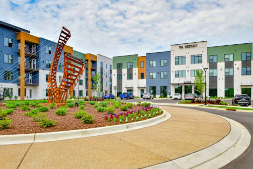 A modern building complex with a sculpture in the front.