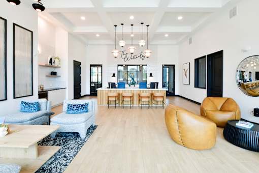 A spacious living lobby with a wooden floor and a variety of seating options.